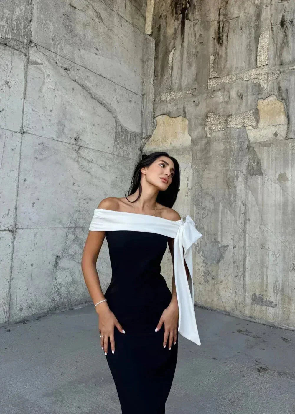 Robe midi asymétrique noire et blanche à une épaule, avec un nœud. Tissu léger et fluide, parfaite pour des occasions…