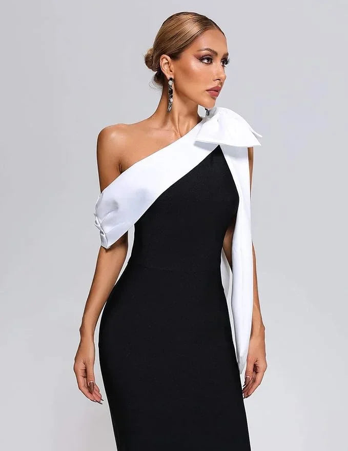 Robe midi asymétrique noire et blanche à une épaule, en tissu léger avec un nœud décoratif sur l'épaule gauche.
