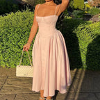 Robe midi rose en coton avec bustier ajusté et jupe évasée, idéale pour les journées d'été.