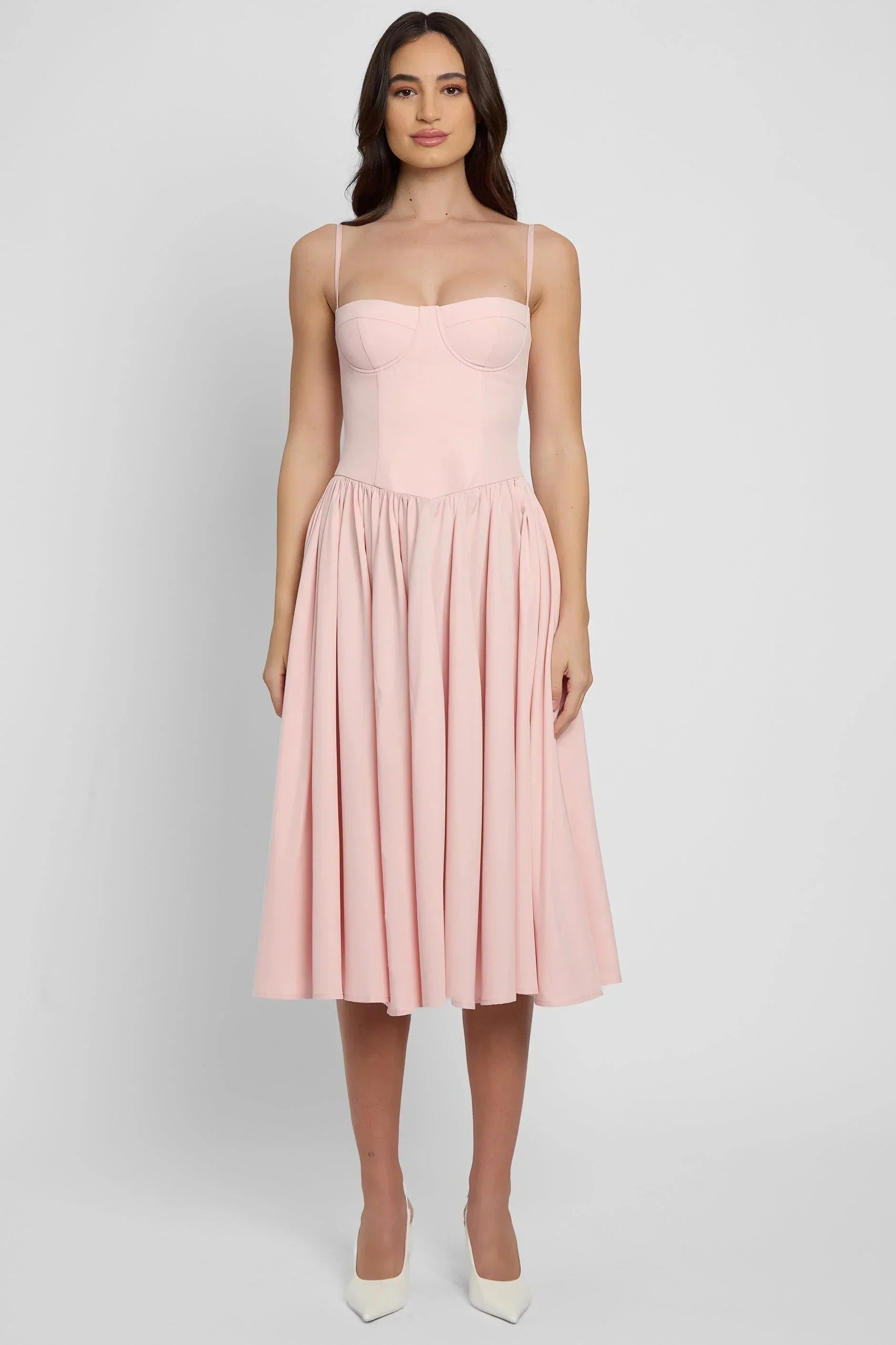 Robe midi rose en coton, bustier ajusté et jupe évasée, parfaite pour l'été avec ses fines bretelles et des détails délicats.