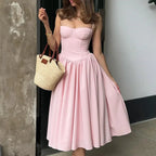 Robe midi rose avec bustier, jupe évasée en coton léger, parfaite pour l'été et les occasions décontractées.