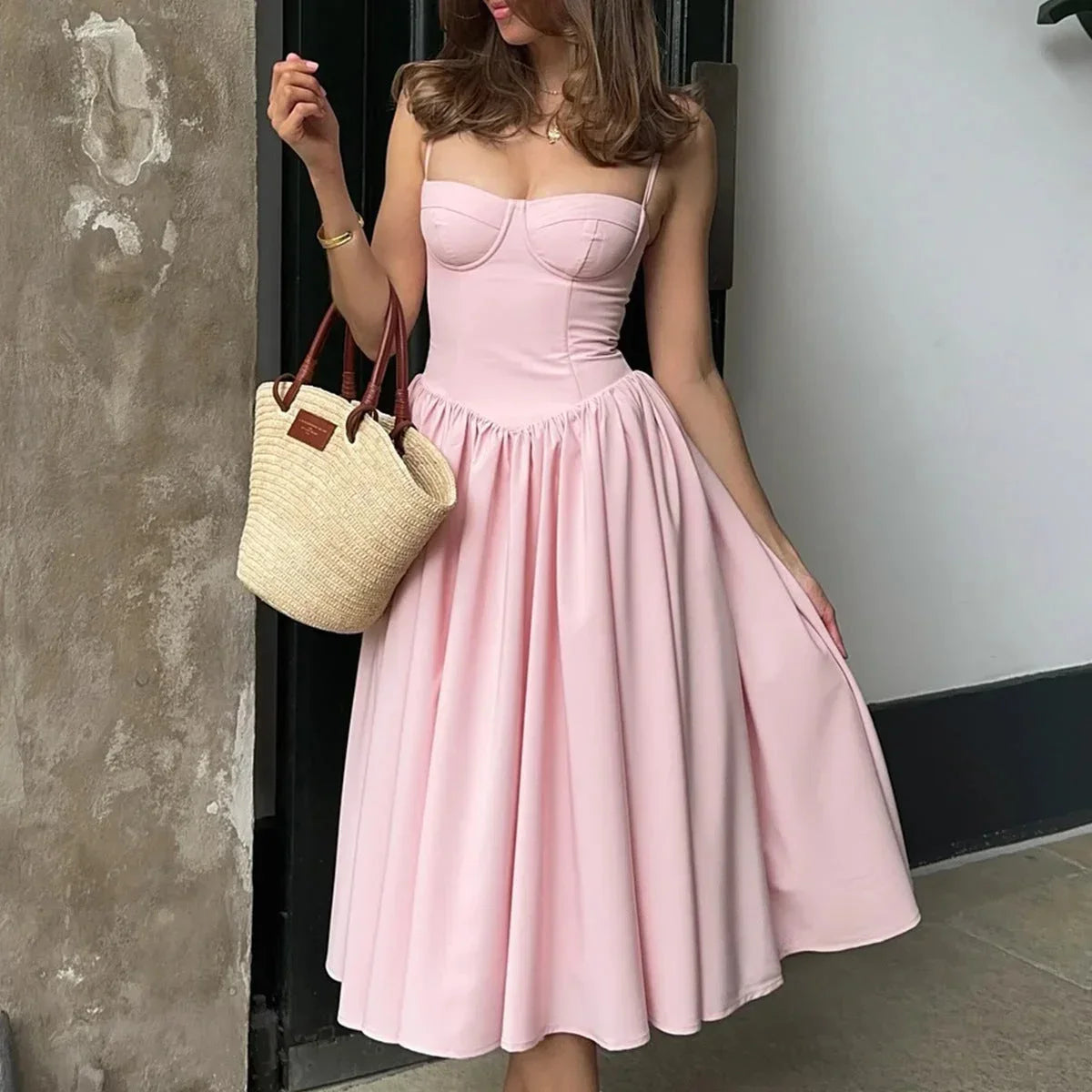 Robe midi rose avec bustier, jupe évasée en coton léger, parfaite pour l'été et les occasions décontractées.