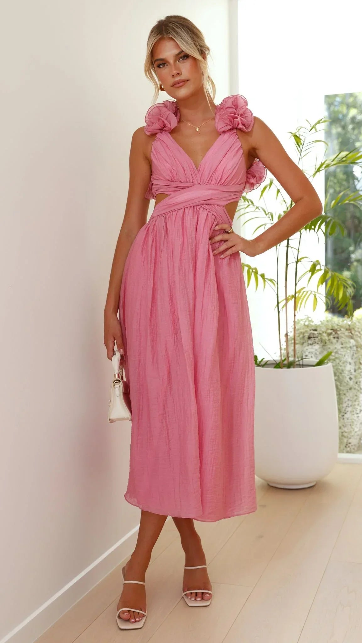 Robe midi rose, bustier torsadé, en tissu léger, avec volants fluides pour femme, parfaite pour les occasions estivales.