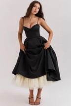 Robe midi satin noire avec tulle crème, bretelles fines et coupe élégante, idéale pour des événements habillés.