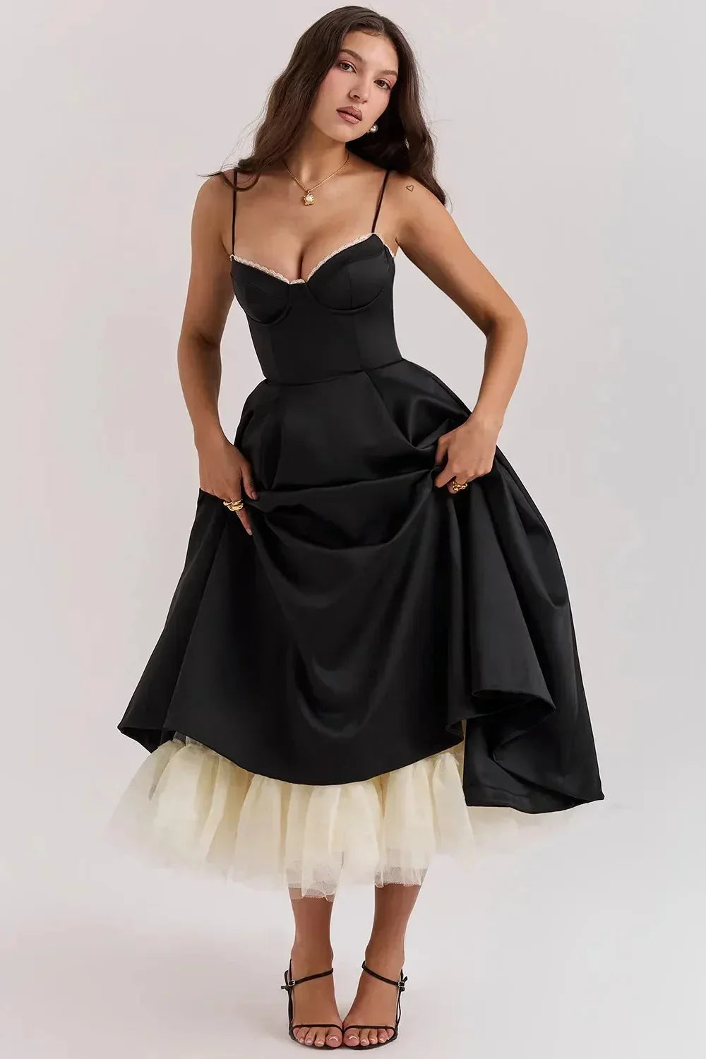 Robe midi satin noire avec tulle crème, bretelles fines et coupe élégante, idéale pour des événements habillés.