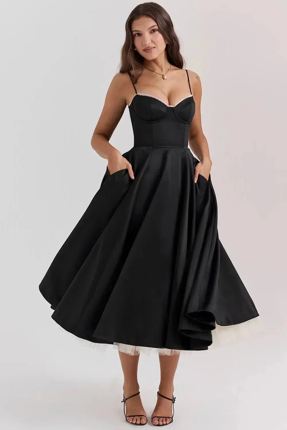 Robe midi satinée noire, tulle crème doux, bretelles fines, idéale pour des occasions formelles.