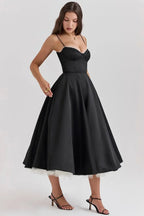 Robe midi satinée noire avec tulle crème, bretelles fines, idéale pour les soirées élégantes.