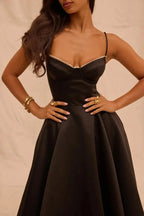 Robe midi noire en satin avec tulle crème, bretelles fines et design élégant pour soirées spéciales.