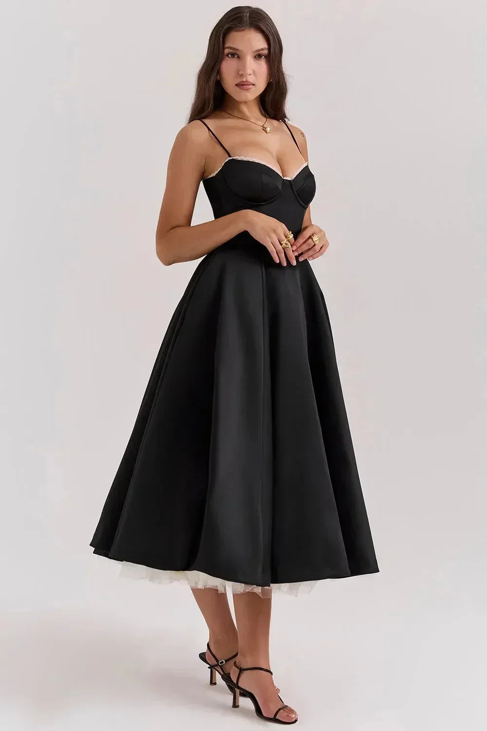 Robe midi noire en satin avec tulle crème, design à bretelles fines et coupe élégante pour soirées.