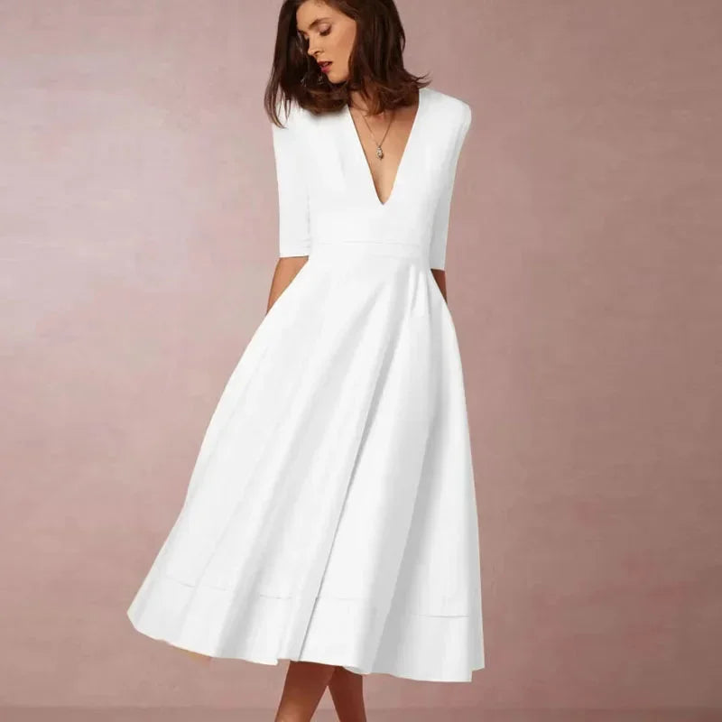Robe midi évasée avec col en V, manches 3/4, tissu lisse et poches, idéale pour une invitée à un mariage.
