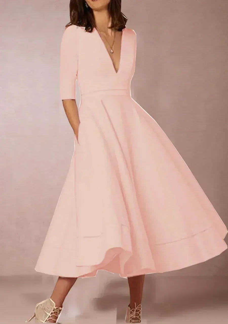 Robe midi évasée en tissu lisse, col en V, manches 3/4 et poches, parfaite pour un mariage invitée.