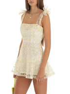 Robe courte A-ligne en coton léger, ornée de dentelle et nœuds aux épaules, idéale pour les soirées d'été.