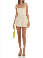 Robe courte A-ligne en tissu léger, ornée de dentelle et de nœuds aux épaules, idéale pour des soirées d'été élégantes.