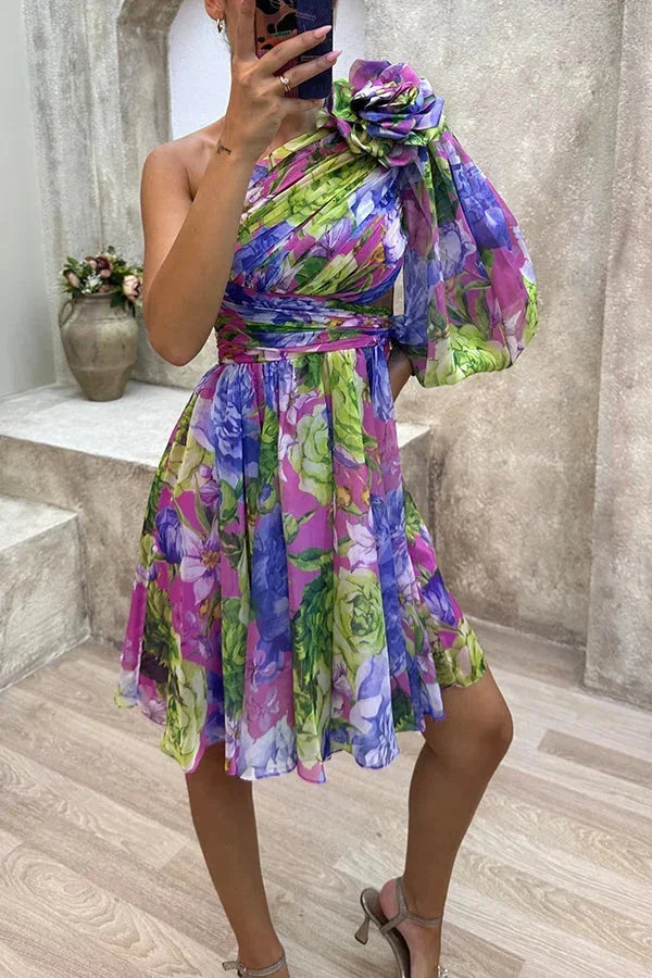 Robe courte asymétrique fleurie à une manche, en tissu léger, parfaite pour les soirées de printemps. Pattern floral vibrant.
