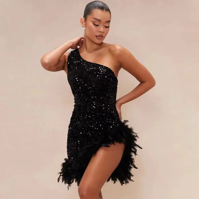 Robe courte asymétrique en sequins argentés, ornée de plumes sur l'ourlet, idéale pour des soirées de clubbing élégantes.