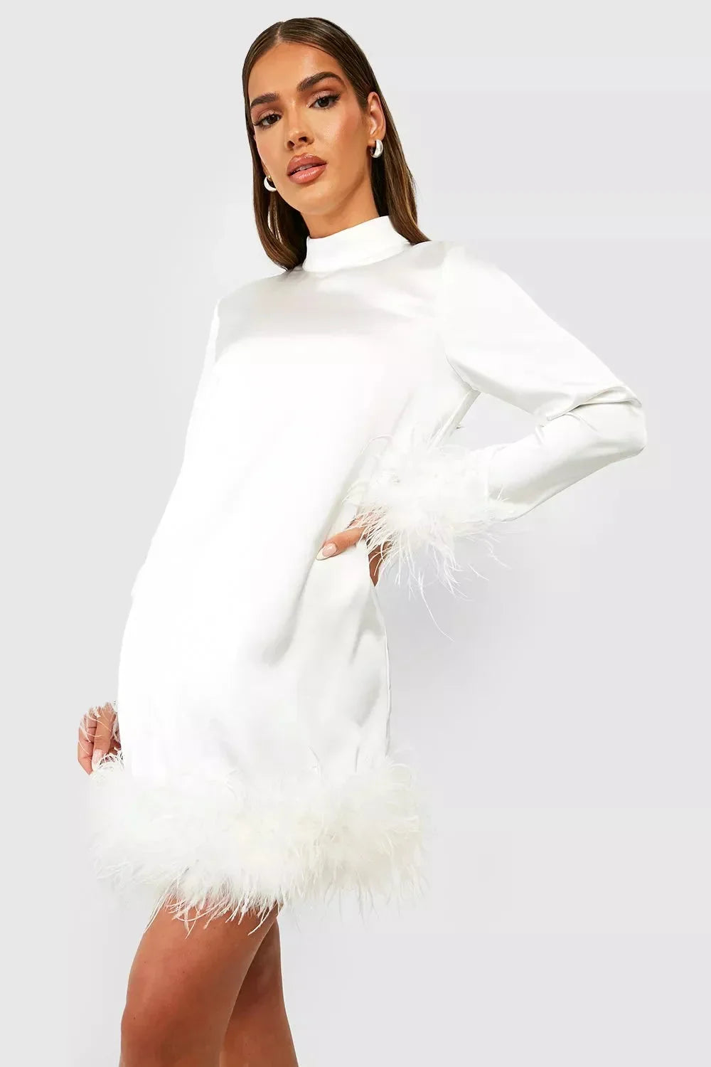 Robe courte blanche en tissu fluide, manches longues ornées de plumes, coupe droite élégante pour événements en soirée.