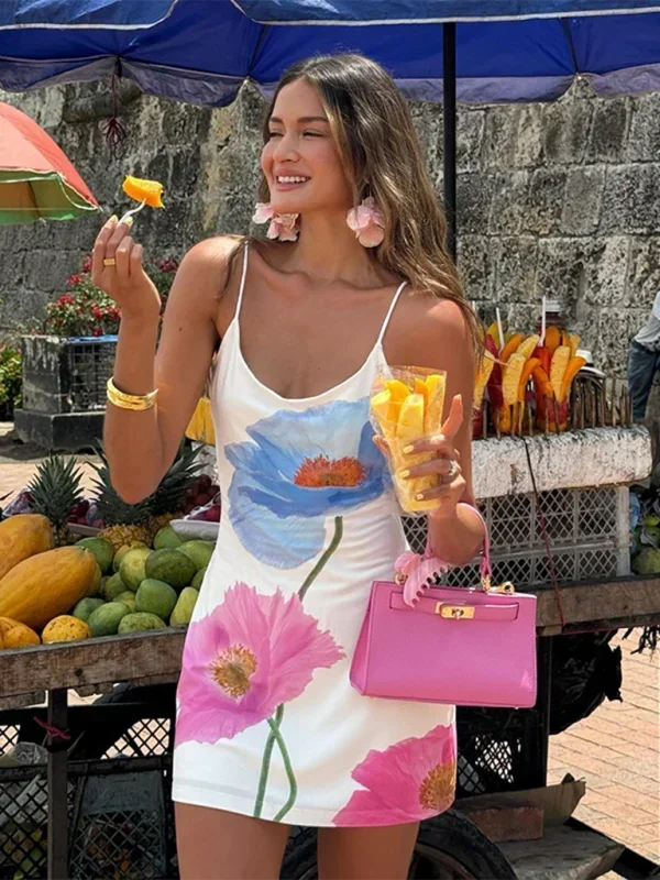 Robe courte blanche en coton avec motifs floraux colorés, bretelles fines idéale pour un look d'été à la plage.