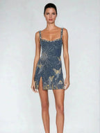 Robe courte bleu avec motifs célestes dorés, bretelles fines et découpe évasée scintillante pour soirées élégantes.