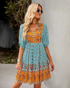 Robe courte bohème multicolore avec col V, manches courtes élastiquées, idéale pour les journées d'été à la plage.