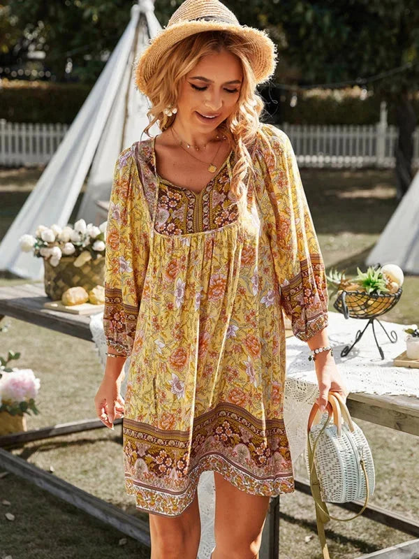 Robe courte bohème en viscose, imprimée de fleurs, manches 3/4 et col V, idéale pour des journées estivales à la plage.