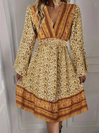 Robe courte boho en tissu léger avec imprimé doré, manches cloche, décolleté plongeant et coupe fluide pour grandes tailles.