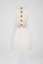 Robe courte ajustée col halter avec boutons dorés, en tissu extensible, idéale pour des soirées élégantes.