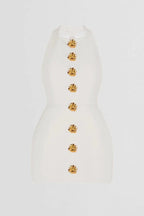 Robe courte ajustée avec col halter, boutons dorés et tissu extensible, parfaite pour les soirées élégantes.