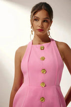 Robe courte col halter ajustée avec boutons dorés, idéale pour une soirée, en tissu doux et léger.