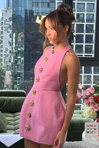 Robe courte ajustée avec boutons dorés, col halter, idéale pour les soirées, en tissu léger et confortable.