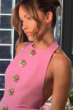 Robe courte ajustée avec boutons dorés, col halter et tissu doux, idéale pour les soirées élégantes.