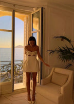 Robe courte bustier en tissu léger avec motif floral en relief, idéale pour soirées et cocktails.