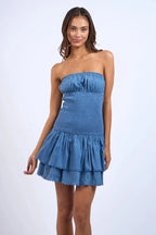 Robe courte bustier smockée bleu avec volants, en tissu léger et fluide, parfaite pour l'été et les journées à la plage.