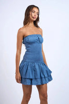 Robe courte bustier smockée bleu avec volants, en tissu léger et fluide, idéale pour l'été et les journées à la plage.