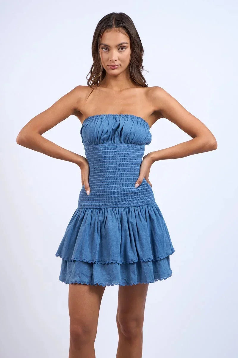 Robe courte bleu à bustier smocké, volants fluides, idéale pour l'été et la plage, en tissu léger et confortable.