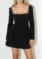 Robe courte à col carré, manches longues, détails en perles et jupe plissée en tissu léger, idéale pour les soirées élégantes.