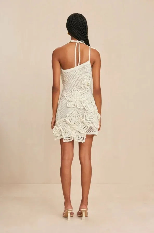 Robe en crochet blanc, épaules dénudées, volants délicats, motifs floraux, parfaite pour les soirées d'été.