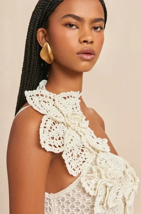 Robe courte blanche en crochet avec épaules dénudées, volants et motifs floraux, idéale pour les soirées d'été.