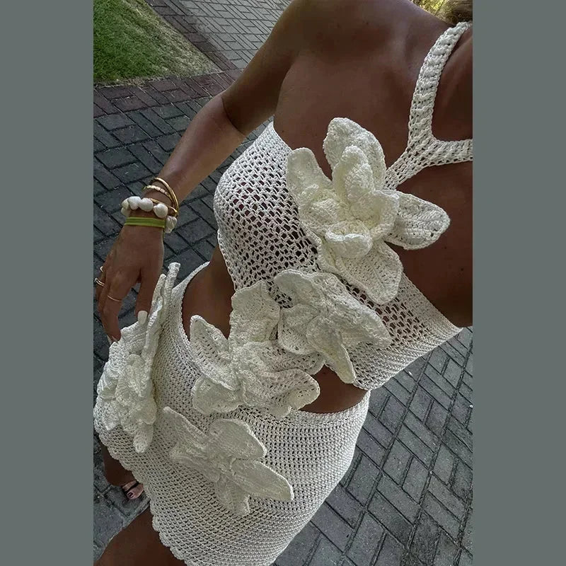 Robe courte en crochet avec découpes, décolleté licou, idéale pour les journées d'été à la plage. Tissu léger et aéré.