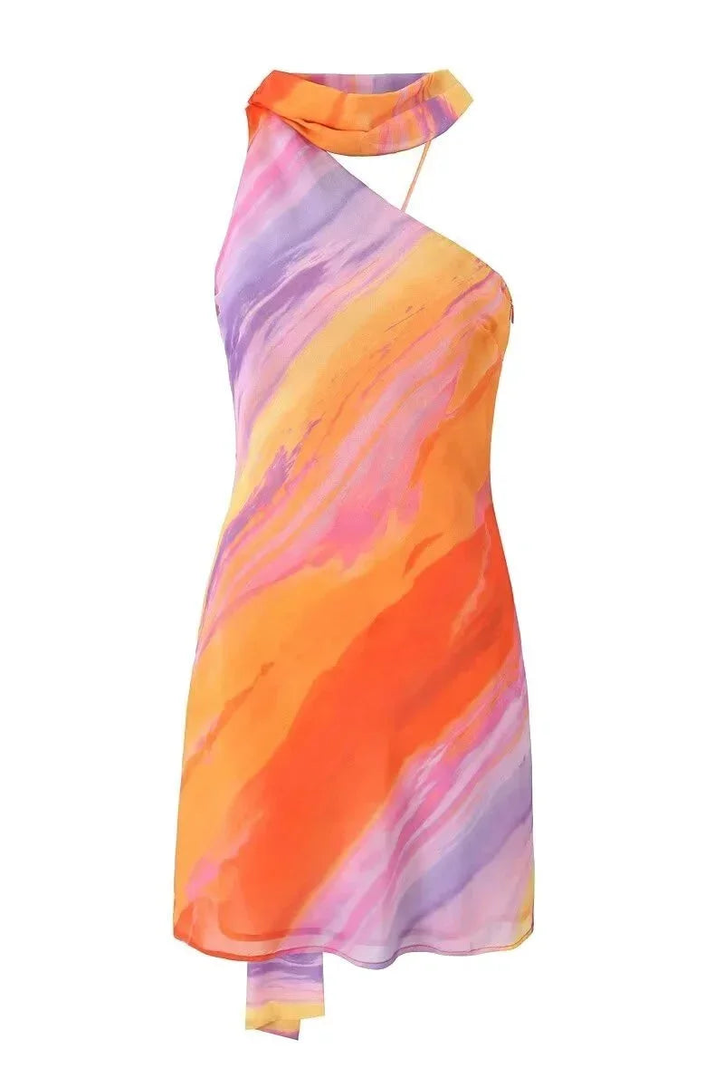Robe courte à dégradé de couleurs coucher de soleil, col licou, tissu fluide et design asymétrique pour soirées d'été.