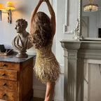 Robe courte dorée avec franges scintillantes, bretelles fines, idéale pour soirées, en tissu doux et léger.