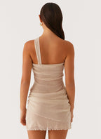 Robe courte drapée beige à une épaule, en tissu léger, avec un design asymétrique idéal pour des occasions élégantes.