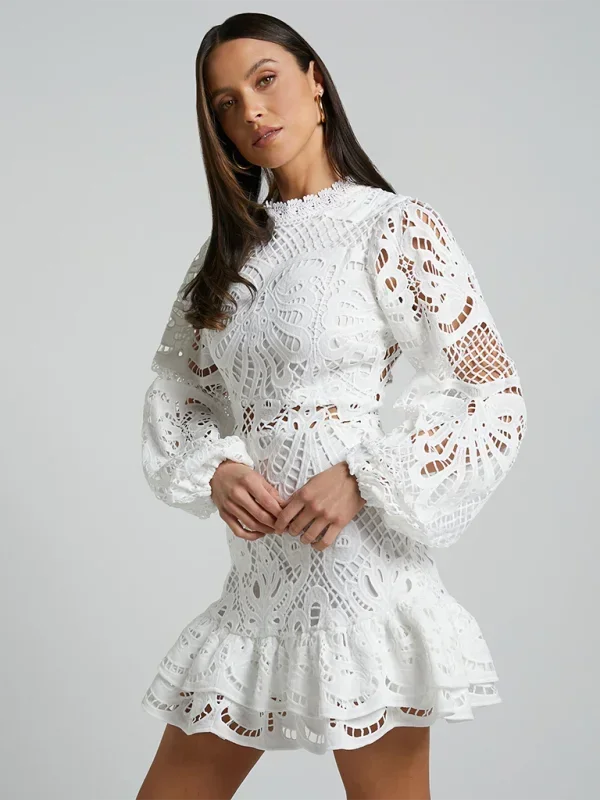 Robe courte en dentelle avec volants, manches longues, disponible en plusieurs couleurs, idéale pour les soirées cocktails.