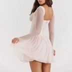 Robe courte en tulle rose blush avec dentelle, manches longues, coupe ajustée pour une soirée élégante.