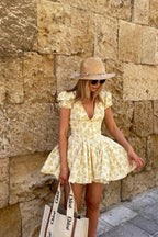 Robe courte fleurie jaune, manches courtes, dos noué, en tissu léger, coupe évasée idéale pour l'été et les journées au jardin.