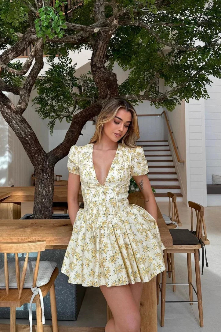Robe courte fleurie jaune à manches courtes, dos noué, en tissu léger, évasée, parfaite pour des journées d'été au jardin.