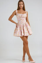 Robe courte fleurie rose avec corset, bretelles larges et tissu léger, idéale pour les journées d'été ensoleillées.