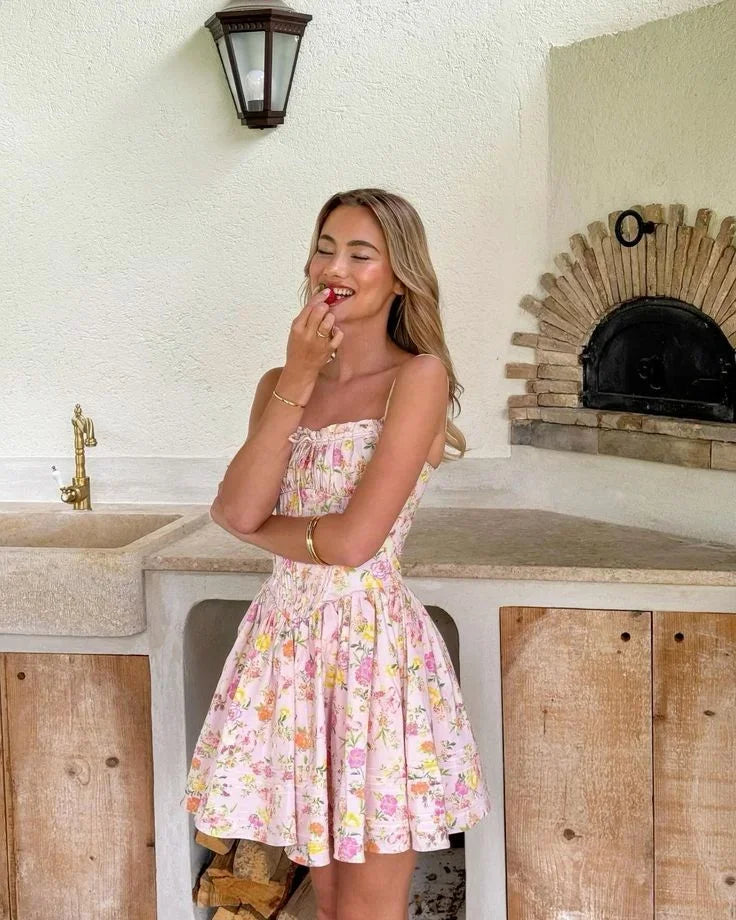 Robe courte fleurie rose à corset, en coton léger, avec bretelles larges et motif floral idéal pour l'été.