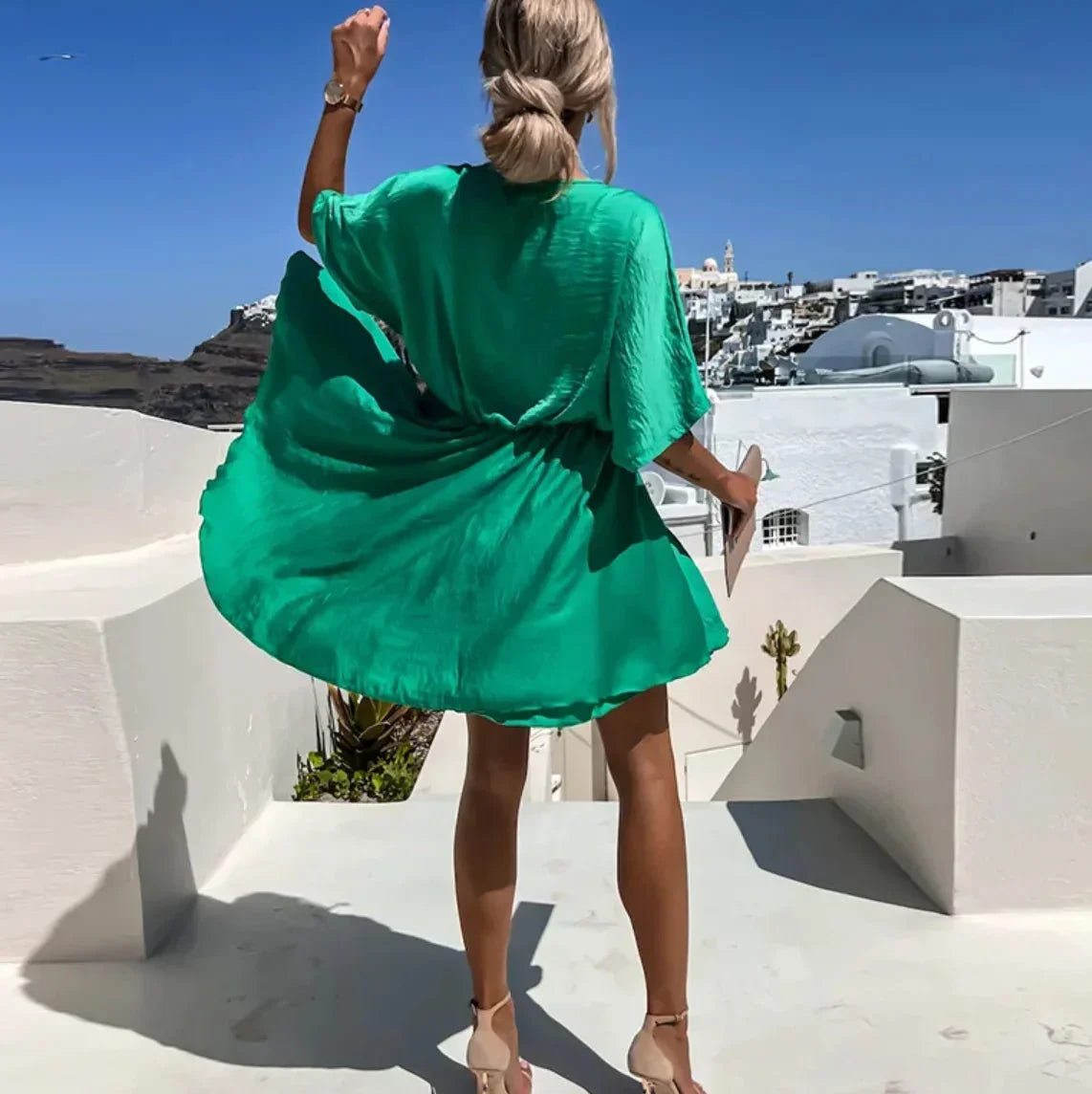 Robe courte fluide en matière légère, col V, cache-cœur avec manches courtes, parfaite pour des journées d'été à la plage.