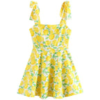 Robe courte sans manches en coton imprimé citron jaune, encolure carrée avec nœud, idéale pour l'été à la plage.