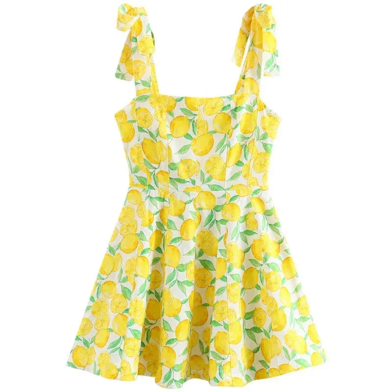 Robe courte sans manches en coton imprimé citron jaune, encolure carrée avec nœud, idéale pour l'été à la plage.